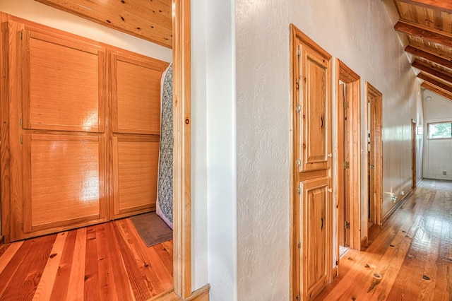 41798 Saddleback Rd, Shaver Lake, CA 93664 - corridor with light wood-style flooring, beamed ceiling, and a textured wall