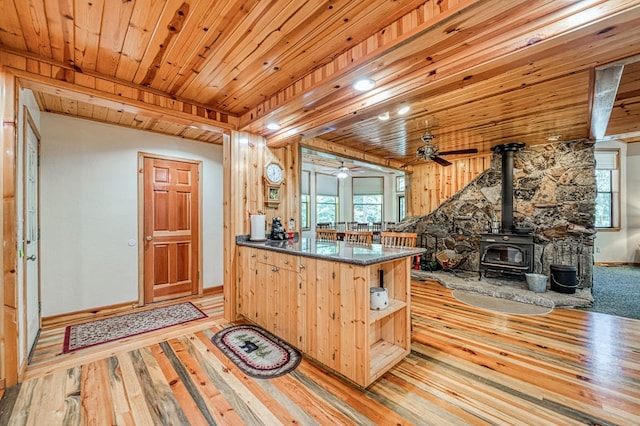 41798 Saddleback Rd, Shaver Lake, CA 93664 - kitchen with a wood stove, open shelves, light wood-type flooring, dark countertops, and healthy amount of natural light