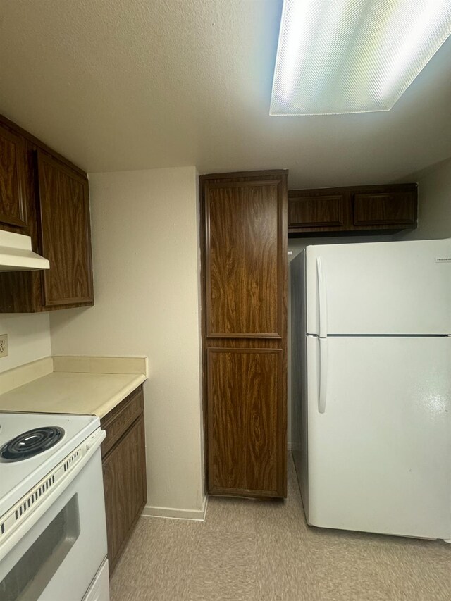 4303 N Emerson Ave, Fresno, CA 93705 - kitchen with white appliances, under cabinet range hood, light countertops, and dark brown cabinetry