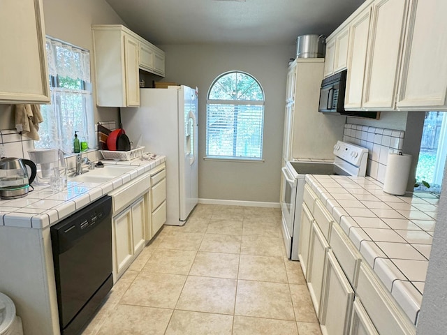 650 N Burgan Ave, Fresno, CA 93727 - kitchen featuring black appliances, tile counters, backsplash, and light tile patterned flooring