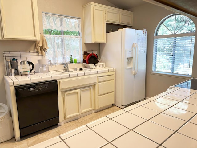 650 N Burgan Ave, Fresno, CA 93727 - kitchen featuring dishwasher, tile counters, white refrigerator with ice dispenser, light tile patterned floors, and vaulted ceiling
