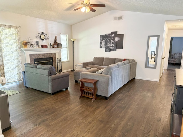 650 N Burgan Ave, Fresno, CA 93727 - living room with a ceiling fan, lofted ceiling, dark wood-type flooring, a tiled fireplace, and a textured ceiling