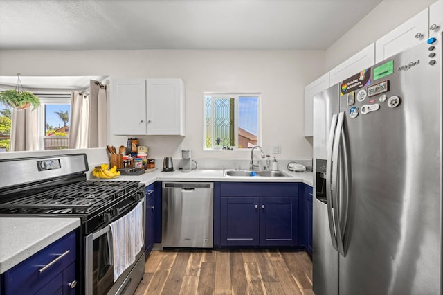 3144 Vista Ave, San Diego, CA 91945 - kitchen with appliances with stainless steel finishes, blue cabinetry, light countertops, wood finished floors, and plenty of natural light