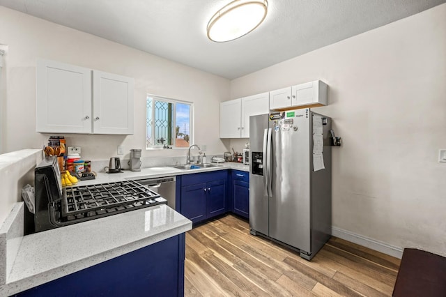 3144 Vista Ave, San Diego, CA 91945 - kitchen with stainless steel appliances, blue cabinets, light wood finished floors, white cabinetry, and light stone countertops