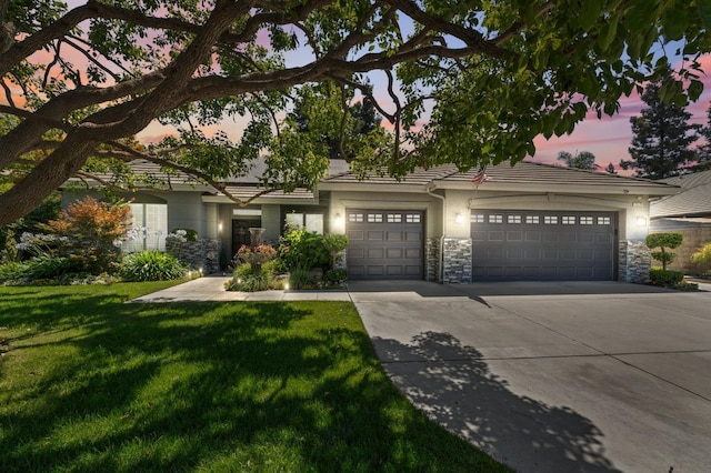 7310 N Katy Ave, Fresno, CA 93722 - view of front of property with stone siding, concrete driveway, a garage, and a lawn