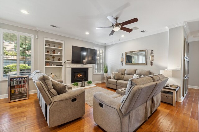7310 N Katy Ave, Fresno, CA 93722 - living area featuring light wood-type flooring, ceiling fan, crown molding, recessed lighting, and a glass covered fireplace