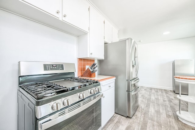 3625 E Cortland Ave, Fresno, CA 93726 - kitchen featuring stainless steel appliances, light wood-style floors, decorative backsplash, light countertops, and white cabinetry