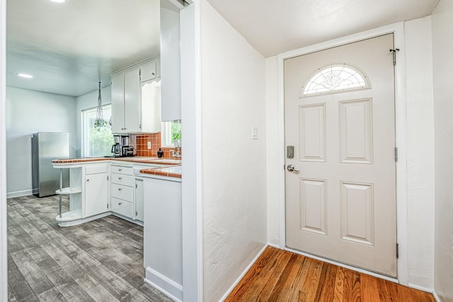 3625 E Cortland Ave, Fresno, CA 93726 - kitchen with wood finished floors, freestanding refrigerator, tile countertops, tasteful backsplash, and recessed lighting