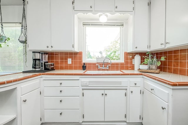 3625 E Cortland Ave, Fresno, CA 93726 - kitchen featuring white cabinetry, decorative backsplash, and light countertops