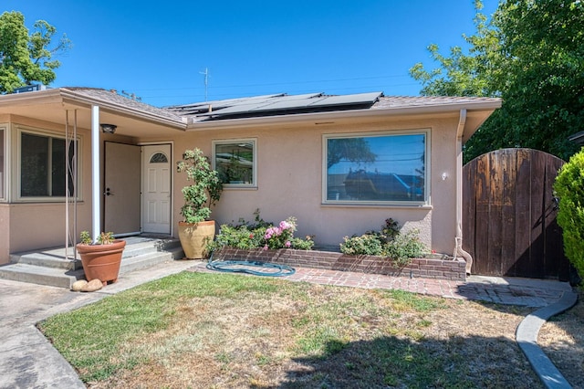 3625 E Cortland Ave, Fresno, CA 93726 - view of front of property with stucco siding, a gate, and solar panels