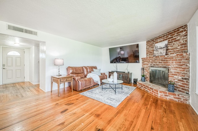 3625 E Cortland Ave, Fresno, CA 93726 - living room featuring wood-type flooring, a textured ceiling, and a fireplace