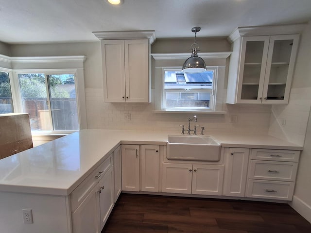 535 E Princeton Ave, Fresno, CA 93704 - kitchen featuring dark wood finished floors, light countertops, glass insert cabinets, hanging light fixtures, and a peninsula