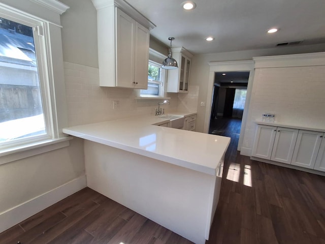 535 E Princeton Ave, Fresno, CA 93704 - kitchen featuring dark wood-style floors, light countertops, backsplash, white cabinetry, and decorative light fixtures