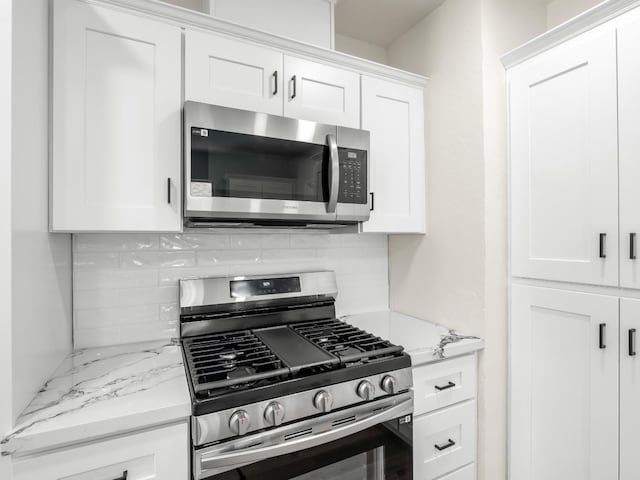 3644 E Illinois Ave, Fresno, CA 93702 - kitchen with stainless steel appliances, tasteful backsplash, white cabinets, and light stone counters
