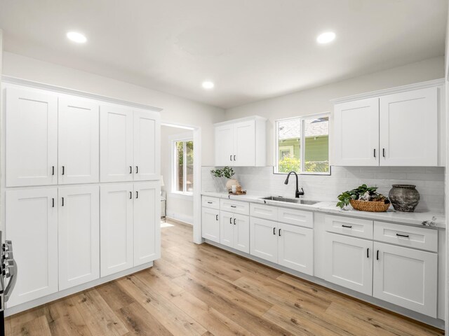 3644 E Illinois Ave, Fresno, CA 93702 - kitchen with backsplash, white cabinetry, light wood finished floors, recessed lighting, and healthy amount of natural light