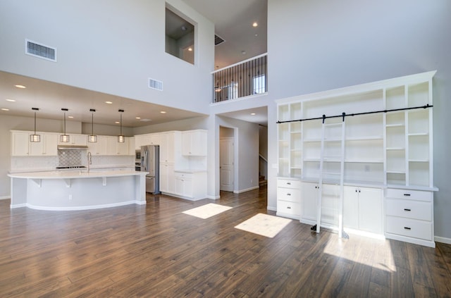 1072 Soledad Ave, Clovis, CA 93619 - unfurnished living room with dark wood-type flooring, a high ceiling, recessed lighting, and a barn door