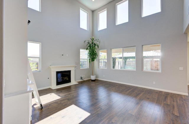 1072 Soledad Ave, Clovis, CA 93619 - unfurnished living room with a towering ceiling, wood-type flooring, and a glass covered fireplace
