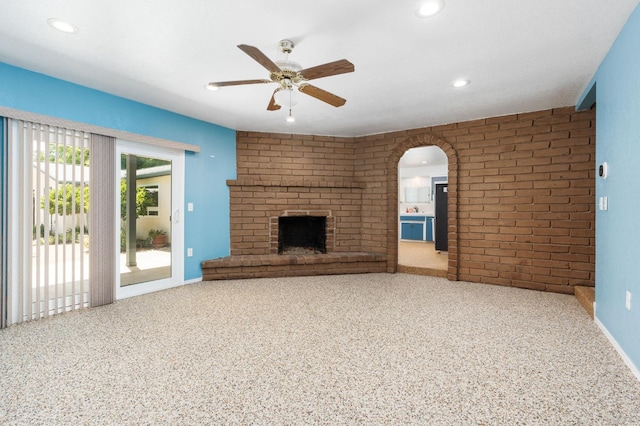 4760 N Rowell Ave, Fresno, CA 93726 - unfurnished living room featuring ceiling fan, recessed lighting, arched walkways, brick wall, and a brick fireplace