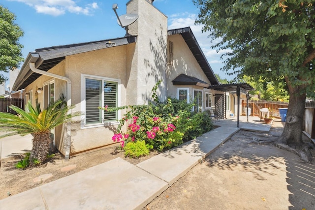 1059 E Fallbrook Ave, Fresno, CA 93720 - back of house featuring a patio, a pergola, stucco siding, and a chimney