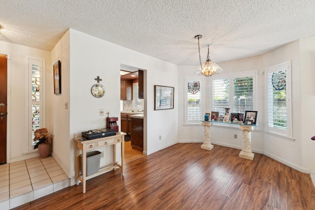 1059 E Fallbrook Ave, Fresno, CA 93720 - dining room with wood finished floors, a textured ceiling, and a chandelier