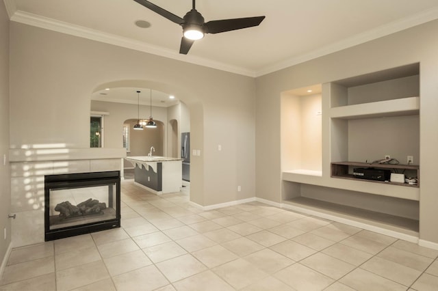 3613 Utah Ln, Clovis, CA 93619 - unfurnished living room with arched walkways, built in features, ornamental molding, light tile patterned floors, and ceiling fan