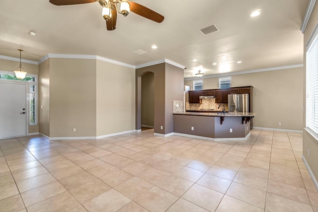 2663 E Spice Way, Fresno, CA 93720 - unfurnished living room featuring arched walkways, light tile patterned floors, recessed lighting, ceiling fan, and crown molding