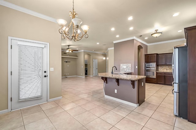 2663 E Spice Way, Fresno, CA 93720 - kitchen featuring appliances with stainless steel finishes, recessed lighting, arched walkways, ornamental molding, and light stone countertops