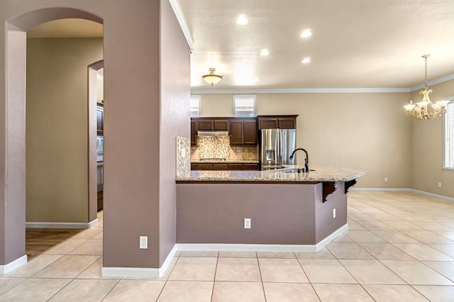 2663 E Spice Way, Fresno, CA 93720 - kitchen featuring stainless steel appliances, crown molding, light stone countertops, dark brown cabinetry, and a chandelier