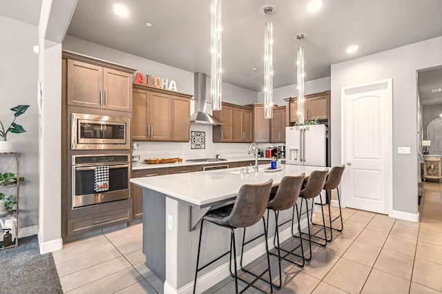 2076 Chennault Ave, Clovis, CA 93611 - kitchen with appliances with stainless steel finishes, wall chimney exhaust hood, an island with sink, light tile patterned floors, and recessed lighting