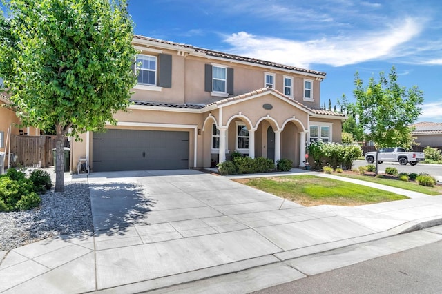 2076 Chennault Ave, Clovis, CA 93611 - mediterranean / spanish-style home with a garage, stucco siding, driveway, and a tiled roof