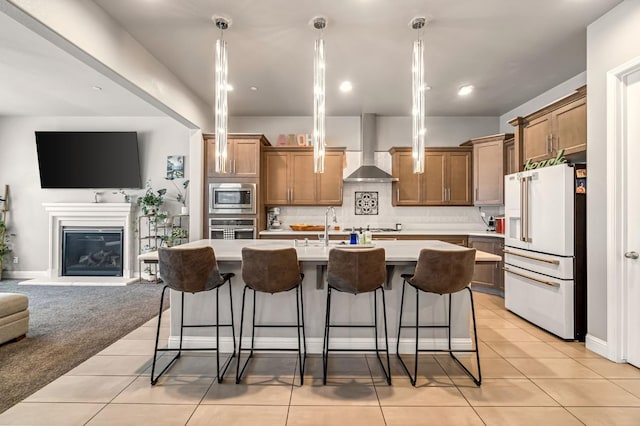 2076 Chennault Ave, Clovis, CA 93611 - kitchen featuring stainless steel appliances, open floor plan, wall chimney exhaust hood, light countertops, and brown cabinets