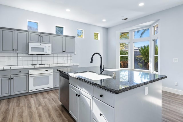 5667 W Bluff Ave, Fresno, CA 93722 - kitchen with white appliances, gray cabinets, an island with sink, tasteful backsplash, and light wood-style floors