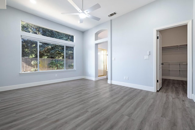 5667 W Bluff Ave, Fresno, CA 93722 - unfurnished bedroom with multiple windows, wood finished floors, a walk in closet, and a closet