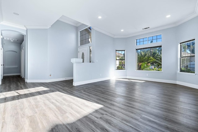 5667 W Bluff Ave, Fresno, CA 93722 - unfurnished living room featuring arched walkways, ornamental molding, dark wood-style flooring, and recessed lighting