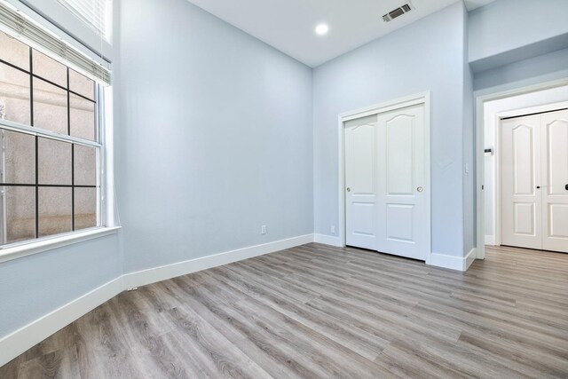 5667 W Bluff Ave, Fresno, CA 93722 - unfurnished bedroom with light wood finished floors, multiple windows, a closet, and recessed lighting