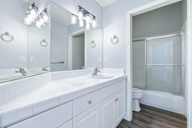 5667 W Bluff Ave, Fresno, CA 93722 - full bath featuring double vanity, shower / bath combination with glass door, and wood finished floors