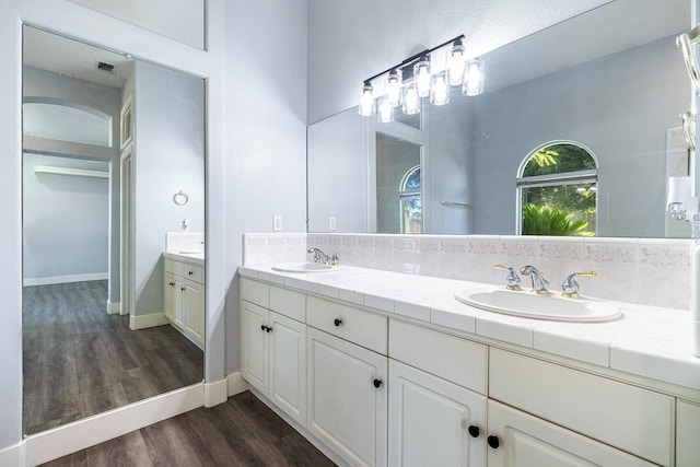 5667 W Bluff Ave, Fresno, CA 93722 - full bathroom with double vanity and wood finished floors