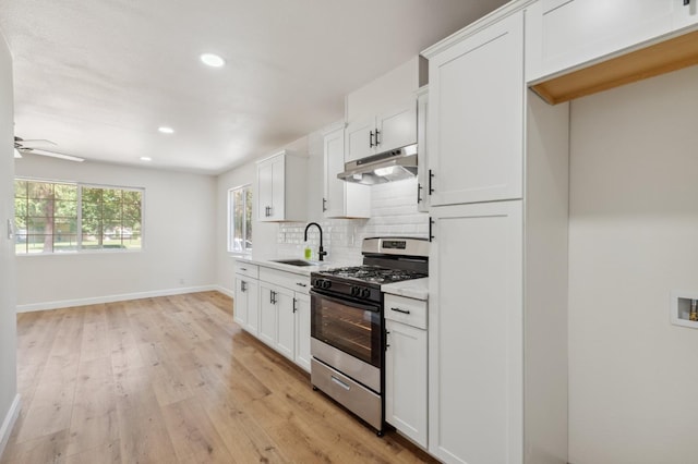 1931 W Ashlan Ave, Fresno, CA 93705 - kitchen featuring stainless steel gas range, under cabinet range hood, light wood-style floors, backsplash, and light countertops