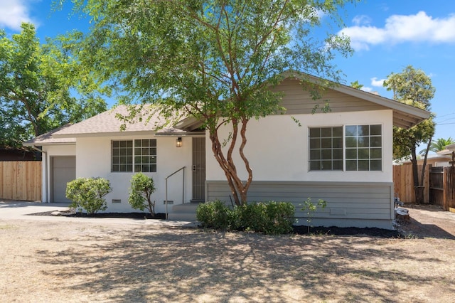 1931 W Ashlan Ave, Fresno, CA 93705 - view of front of home with an attached garage, stucco siding, and driveway