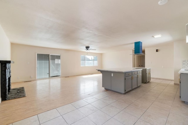2738 S Fairway Ct, Visalia, CA 93277 - kitchen featuring gray cabinetry, range hood, a ceiling fan, light countertops, and open floor plan