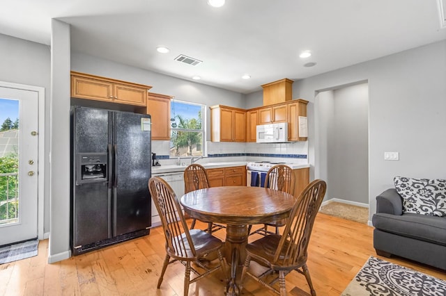 2143 Everglade Ave, Clovis, CA 93619 - kitchen with white appliances, light countertops, decorative backsplash, light wood-style floors, and recessed lighting