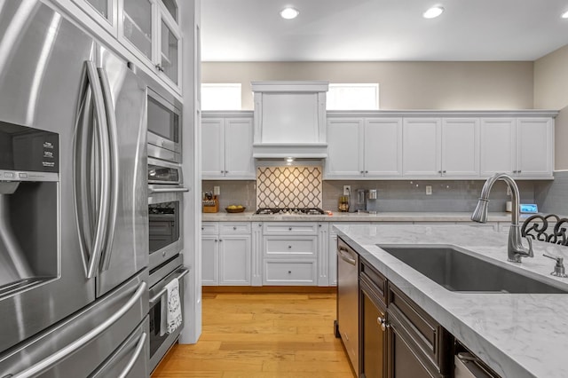 2143 Everglade Ave, Clovis, CA 93619 - kitchen with appliances with stainless steel finishes, white cabinetry, decorative backsplash, light wood-style flooring, and recessed lighting