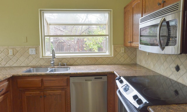 10521 N Doheny Ave, Fresno, CA 93730 - kitchen featuring appliances with stainless steel finishes, tasteful backsplash, and brown cabinetry