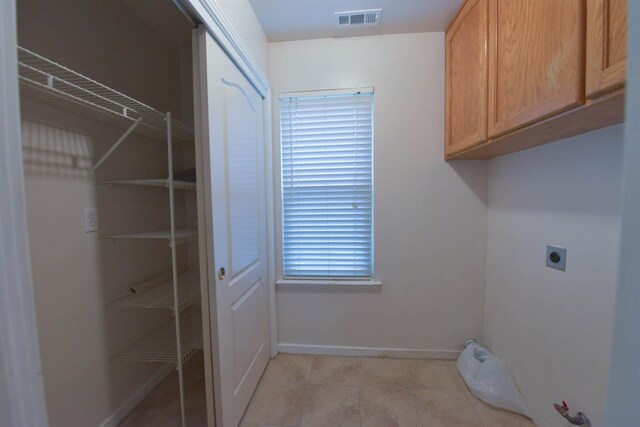 10521 N Doheny Ave, Fresno, CA 93730 - laundry room with cabinet space, light tile patterned flooring, and electric dryer hookup