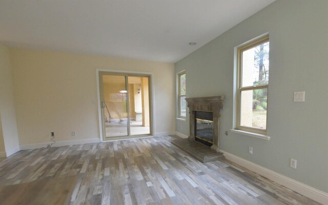 10521 N Doheny Ave, Fresno, CA 93730 - unfurnished living room featuring wood finished floors, a fireplace, and healthy amount of natural light