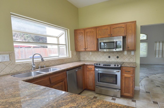 10521 N Doheny Ave, Fresno, CA 93730 - kitchen featuring stainless steel appliances, brown cabinets, backsplash, and light tile patterned floors