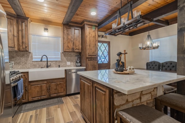 36118 Teaford Poyah, North Fork, CA 93643 - kitchen featuring stainless steel appliances, a wood ceiling with exposed beams, light wood-style flooring, a breakfast bar, and decorative backsplash