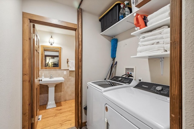 39801 Woody Ln, Shaver Lake, CA 93664 - laundry area with washer and clothes dryer, tile walls, and light wood-type flooring