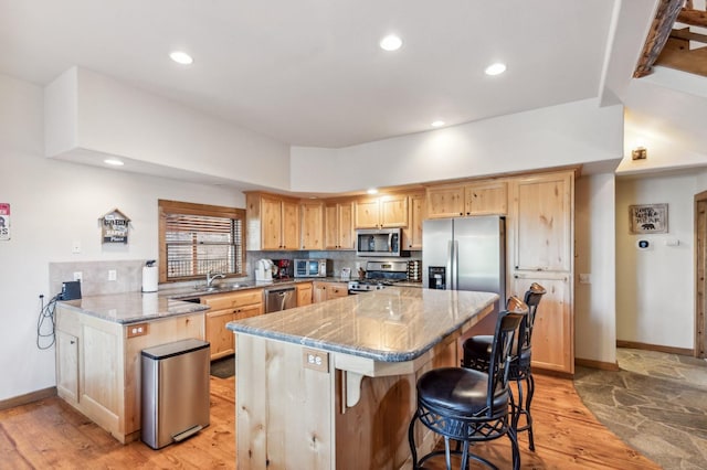 39801 Woody Ln, Shaver Lake, CA 93664 - kitchen with appliances with stainless steel finishes, light brown cabinets, light stone countertops, a kitchen breakfast bar, and light wood-style flooring