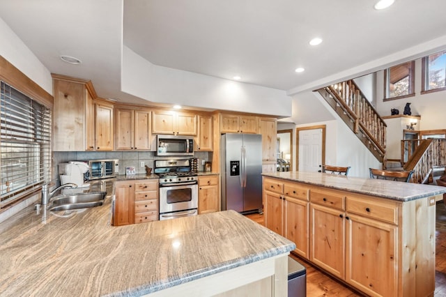 39801 Woody Ln, Shaver Lake, CA 93664 - kitchen with appliances with stainless steel finishes, light brown cabinets, recessed lighting, backsplash, and light stone countertops